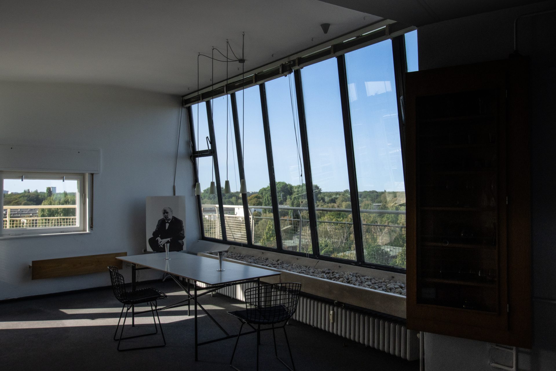Moderne Büroumgebung mit großen Fenstern, Tisch, Stühlen und Blick auf die Natur.