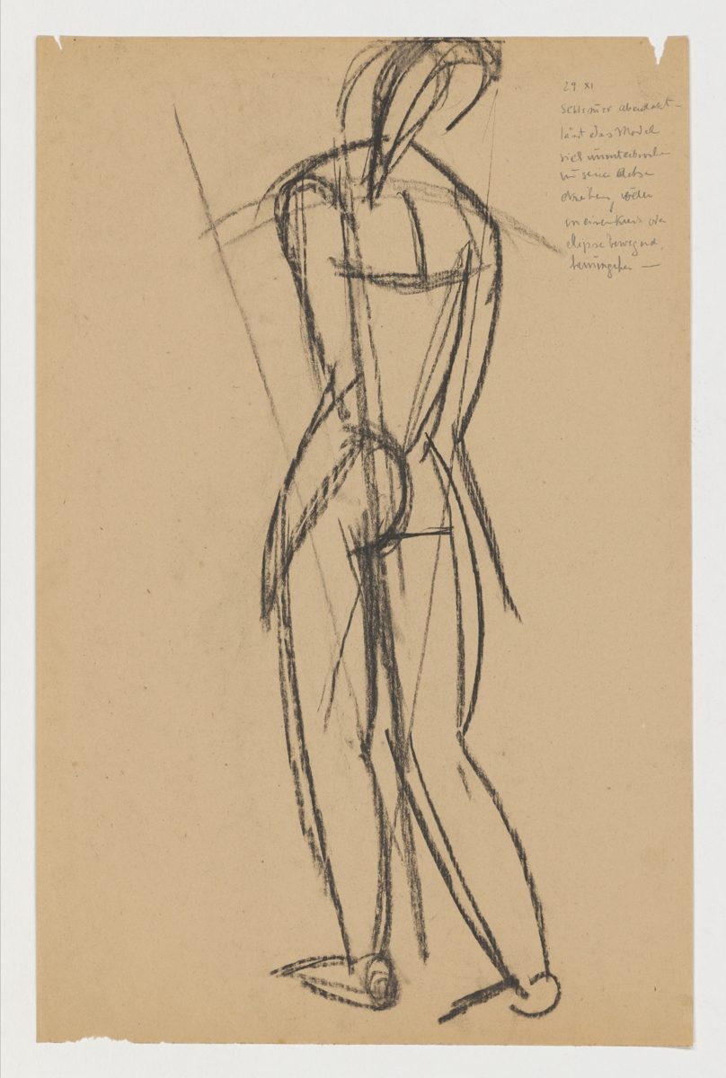 Sketch of a standing female nude in black chalk on brown paper with a handwritten note in the upper right corner.