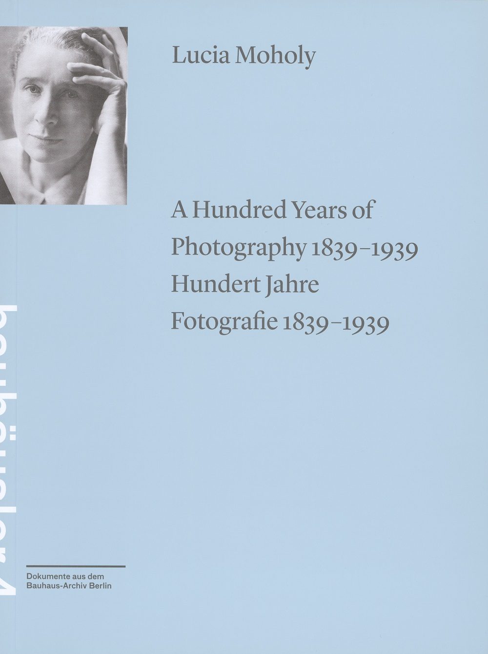 Buchcover mit Portrait von Lucia Moholy und Titel "Hundert Jahre Fotografie 1839-1939" auf blauem Hintergrund.
