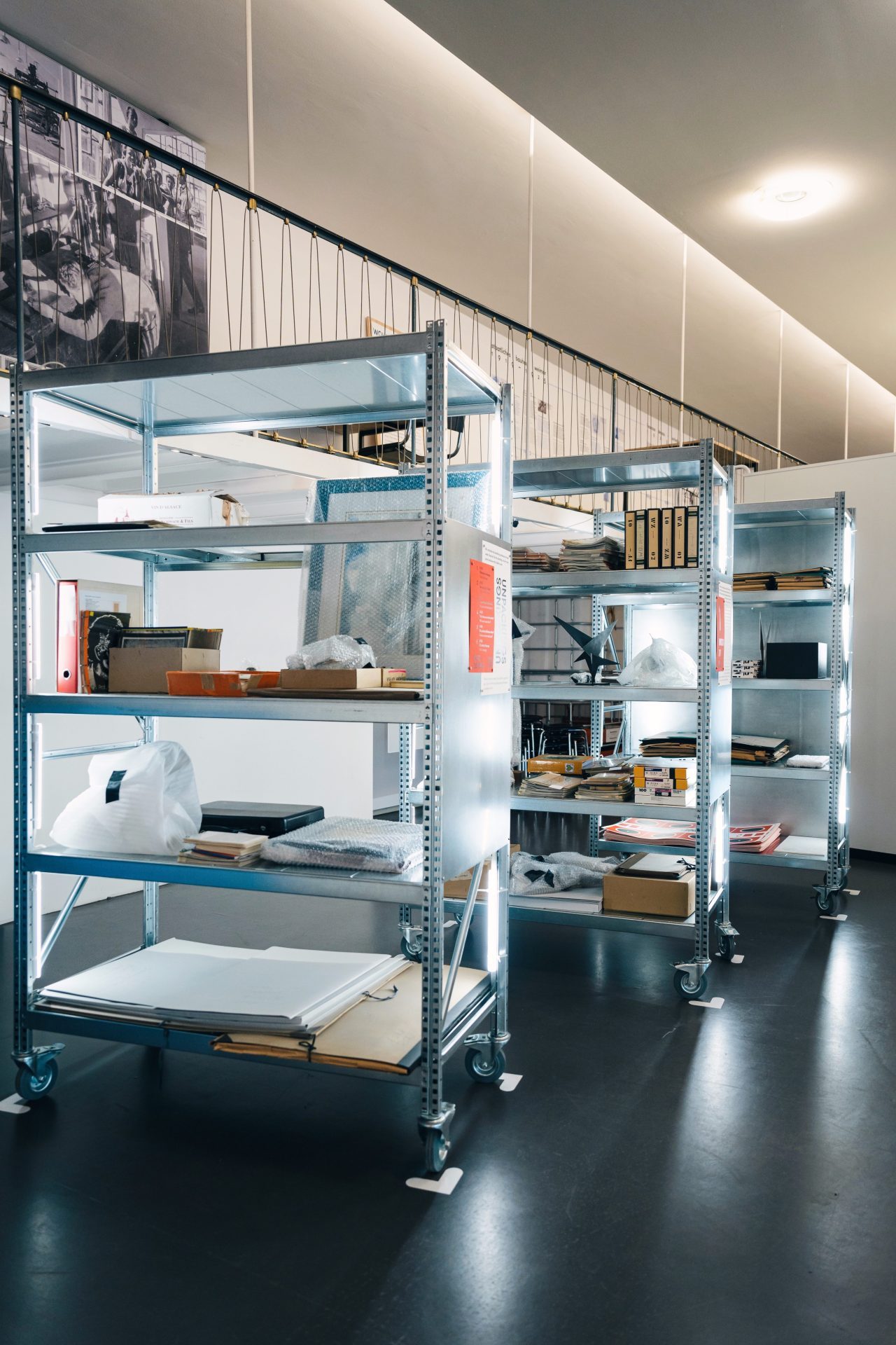 Regale in einem modernen Raum, beladen mit verschiedenen Materialien und Werkzeugen, hinterleuchtet für bessere Sichtbarkeit.