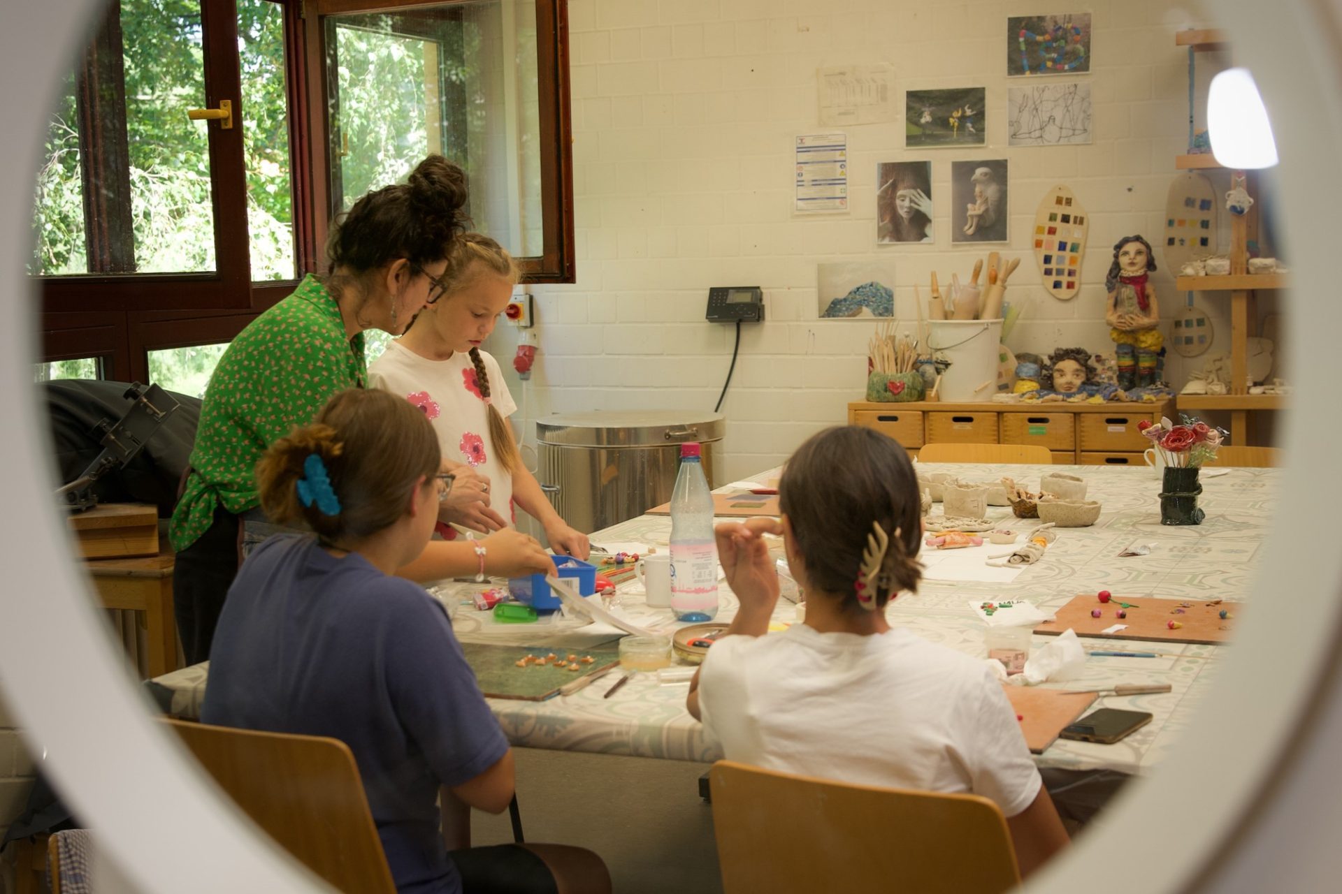 Familienmitglieder basteln gemeinsam an einem Tisch in einem kreativen Atelier, umgeben von Kunstwerken.